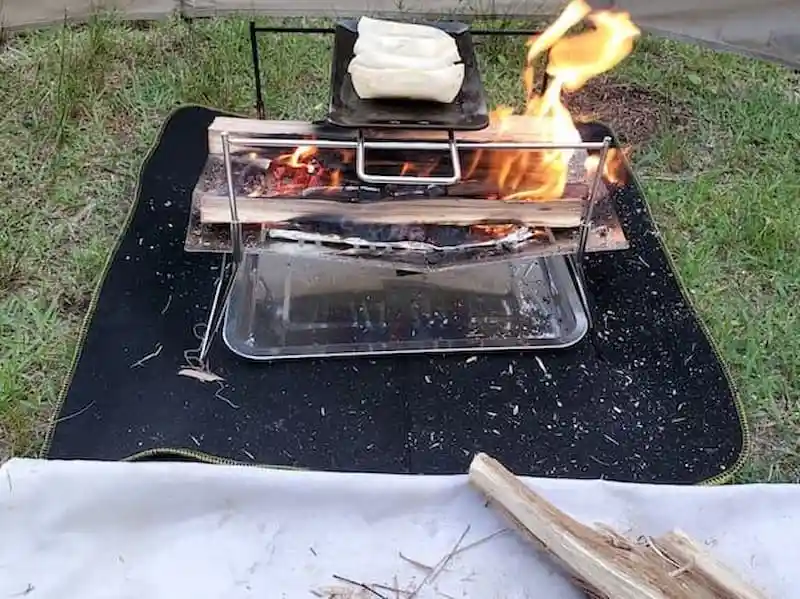 焚き火台に置いた鉄板で焼いている餃子